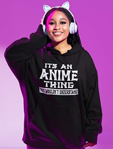 Person wearing a black hoodie with 'It's an Anime Thing' and cat ear headphones